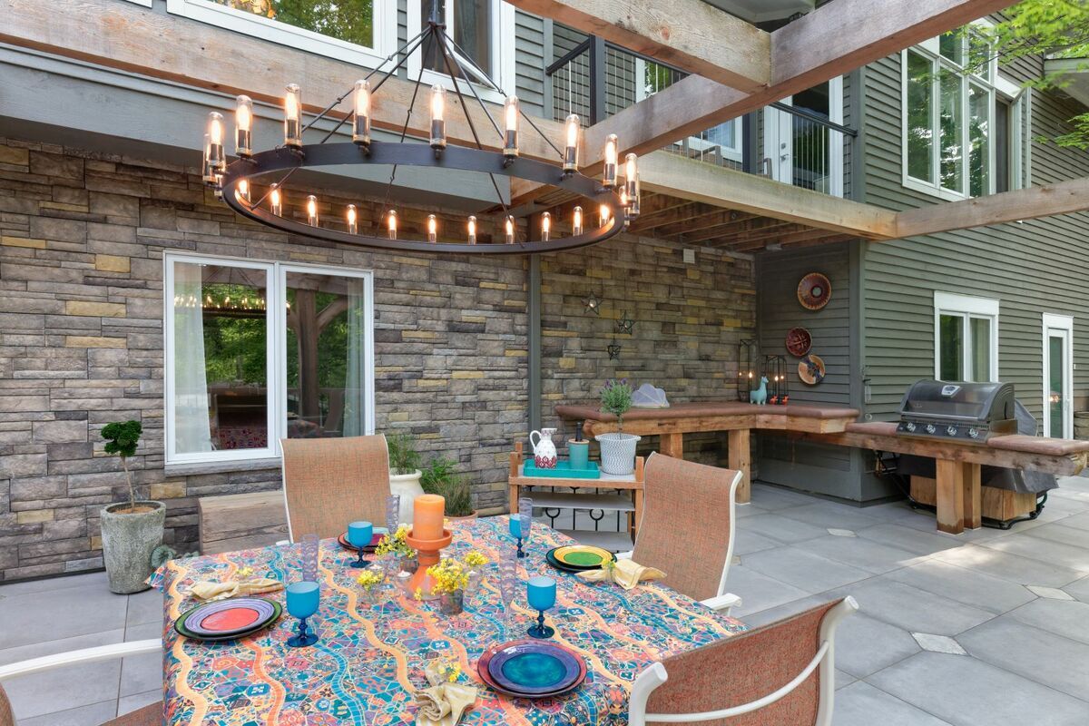 An outdoor patio area with a chandelier hanging from a pergola